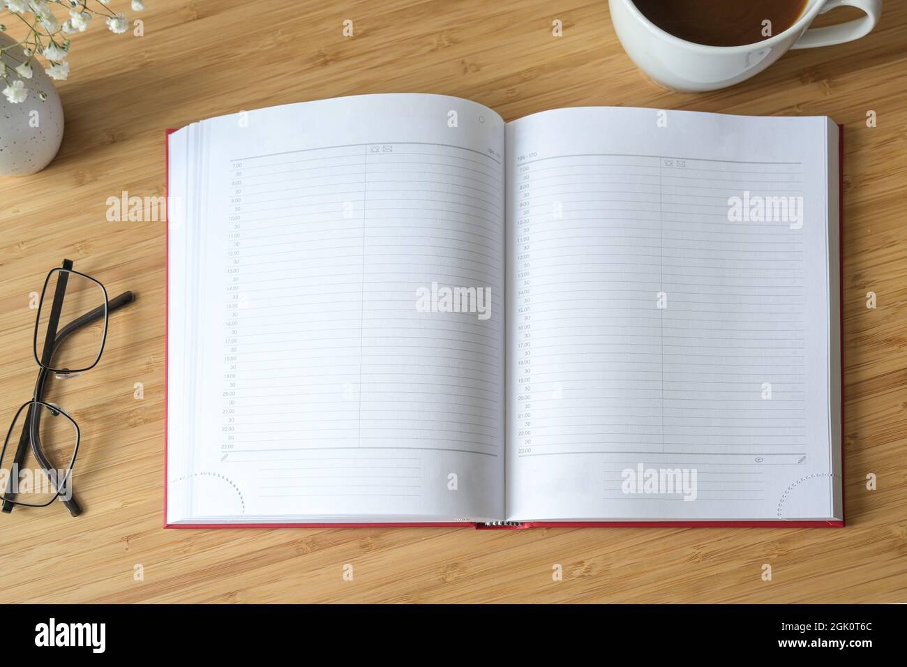 Flat lay mock-up of a blank open diary or appointment calendar on a wooden desk with coffee and glasses, time management concept, copy space, selected Stock Photo