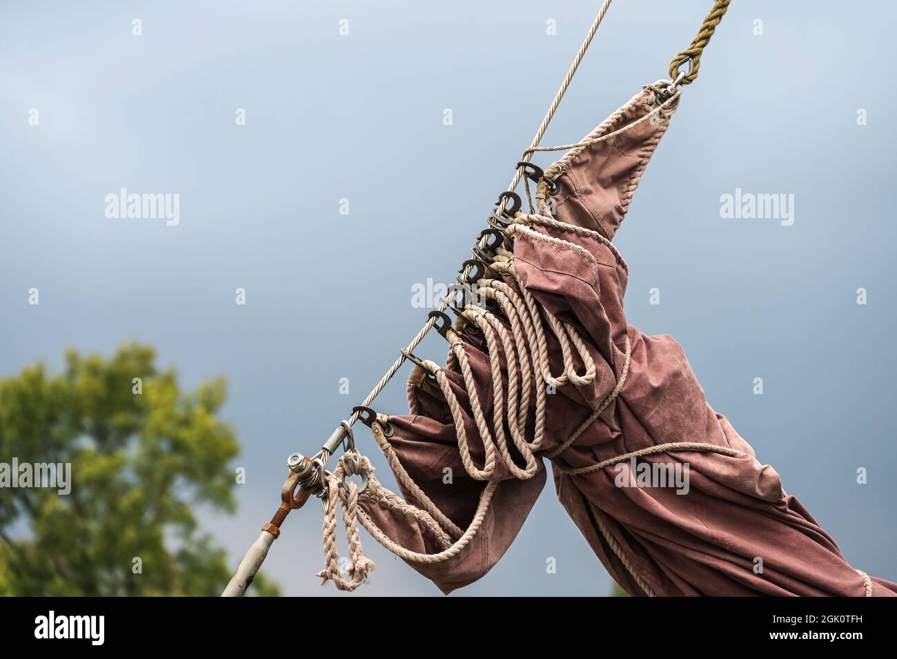 reefed sail on a historic sailing vessel against a dark sky, copy space, selected focus Stock Photo