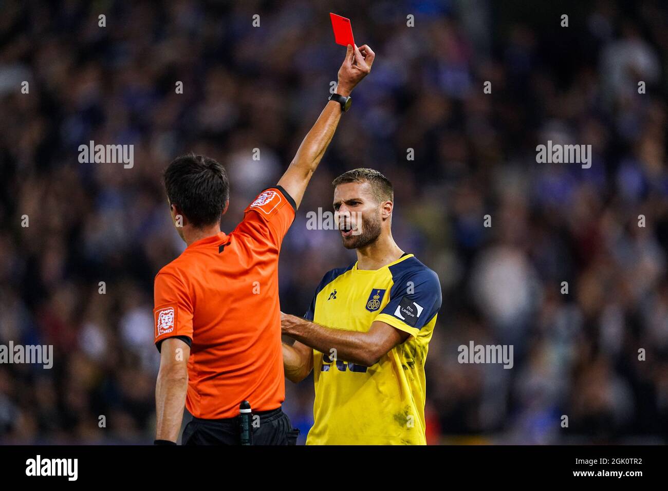 GENK, BELGIUM - SEPTEMBER 12: Referee Erik Lambrechts shows a direct red  card to Jonas Bager of Union SG after checking the VAR during the Jupiler  Pro League match between KRC Genk