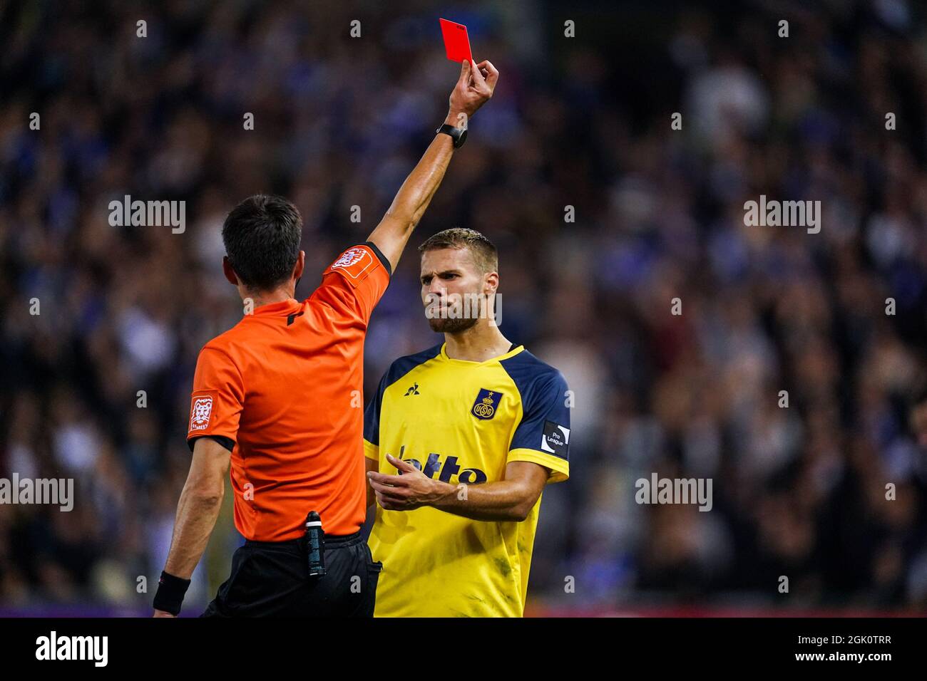 GENK, BELGIUM - SEPTEMBER 12: Referee Erik Lambrechts shows a direct red  card to Jonas Bager of Union SG after checking the VAR during the Jupiler  Pro League match between KRC Genk