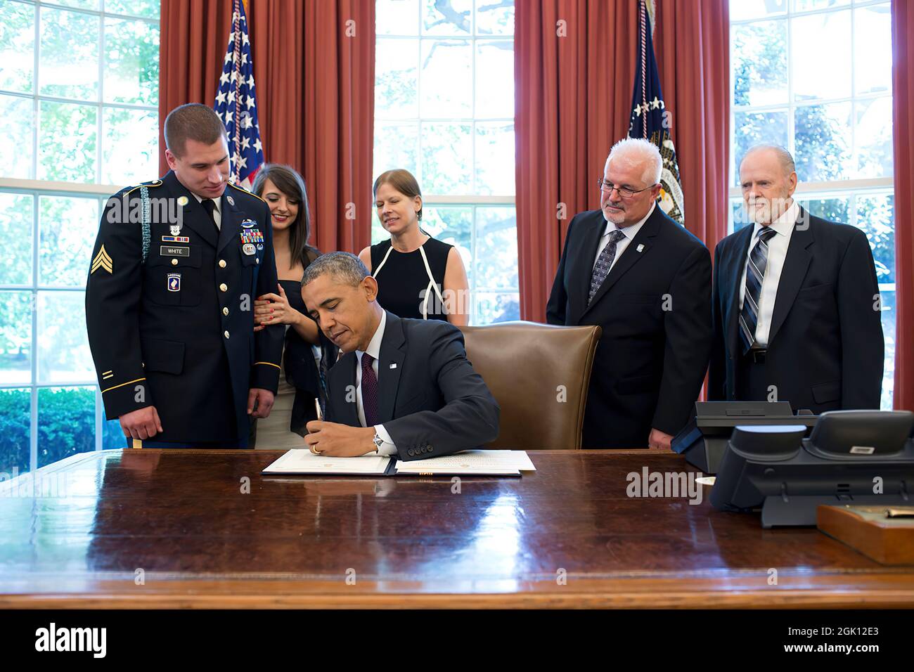 President Barack Obama signs the Medal of Honor award citation for Sergeant Kyle J. White in the Oval Office prior to a Medal of Honor ceremony in the East Room of the White House, May 13, 2014.  Sgt. White received the Medal of Honor for his courageous actions while serving as a Platoon Radio Telephone Operator assigned to C Company, 2nd Battalion (Airborne), 503rd Infantry Regiment, 173rd Airborne Brigade, during combat operations against an armed enemy in Nuristan Province, Afghanistan on November 9, 2007. (Official White House Photo by Pete Souza)   This official White House photograph is Stock Photo
