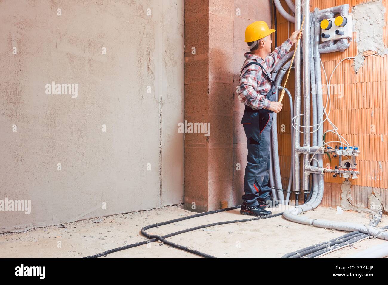Senior male technician measuring the pipe with ruler Stock Photo
