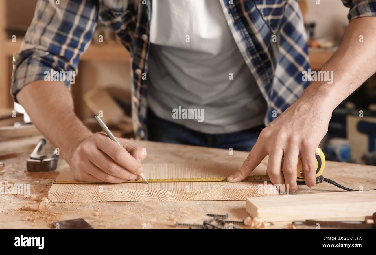 Carpenter marking measurements on piece of wooden board Stock Photo Alamy