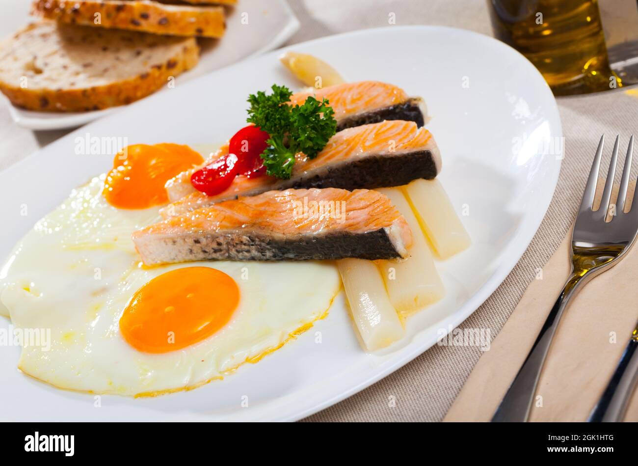 Fried salmon with scrambled eggs and asparagus Stock Photo