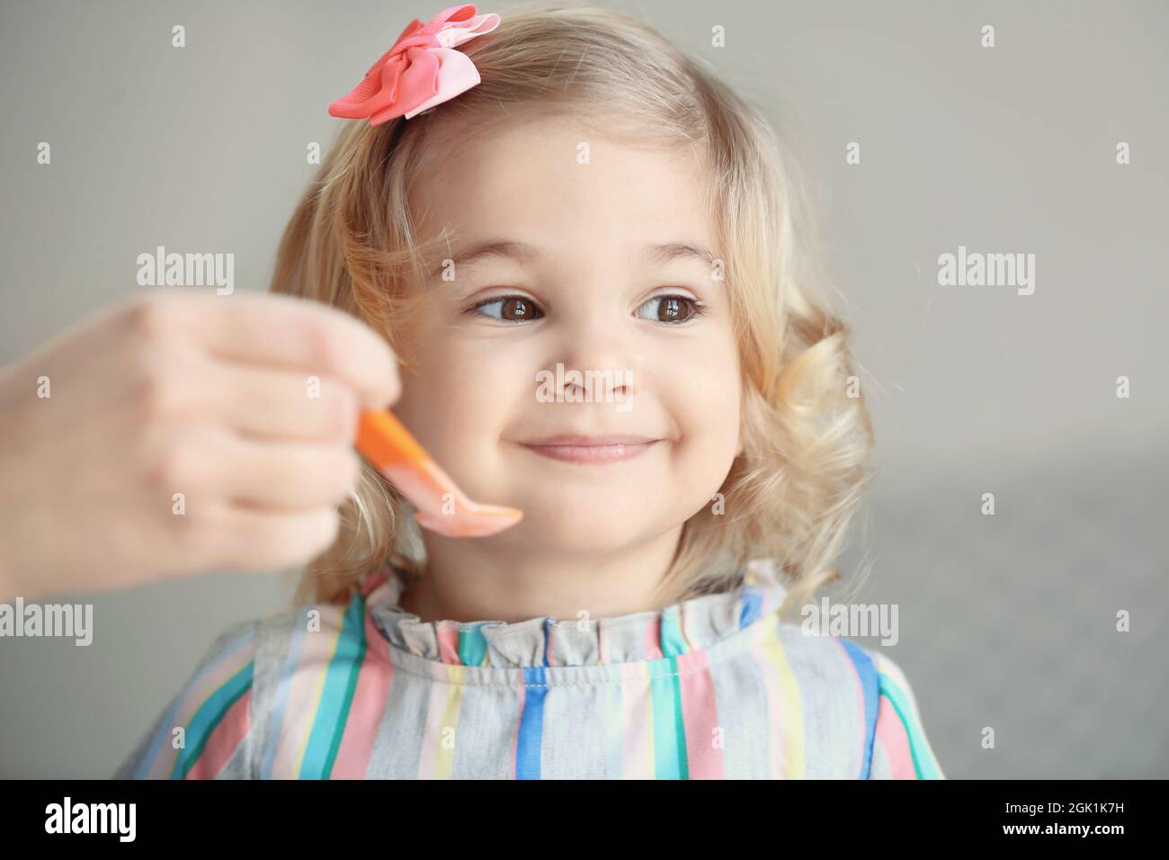 Mother feeding cute little girl with yogurt at home Stock Photo Alamy