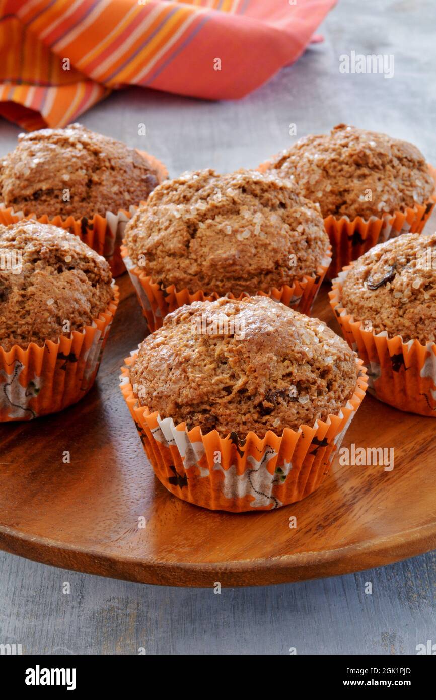 https://c8.alamy.com/comp/2GK1PJD/fresh-baked-bran-muffins-in-halloween-paper-cupcake-liners-on-rustic-wooden-turntable-vertical-format-fall-colors-2GK1PJD.jpg