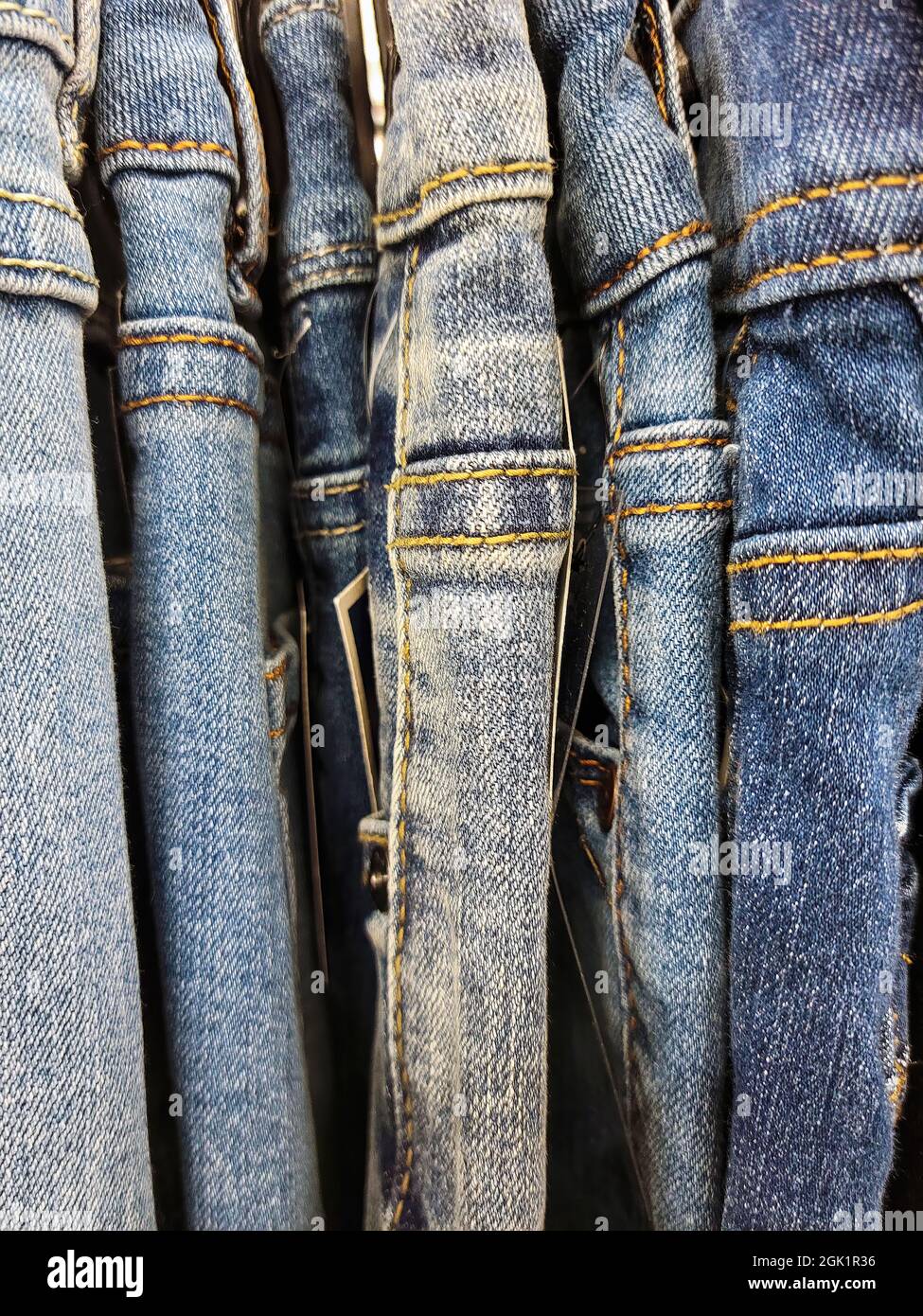 Row of new blue jeans hanging on store clothes rack Stock Photo Alamy