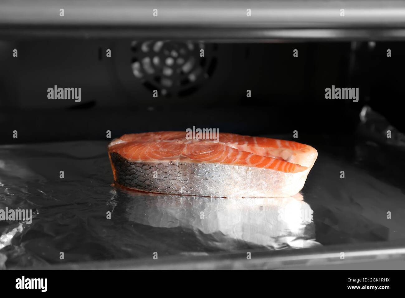 Baking sheet with foil and piece of salmon in oven Stock Photo Alamy