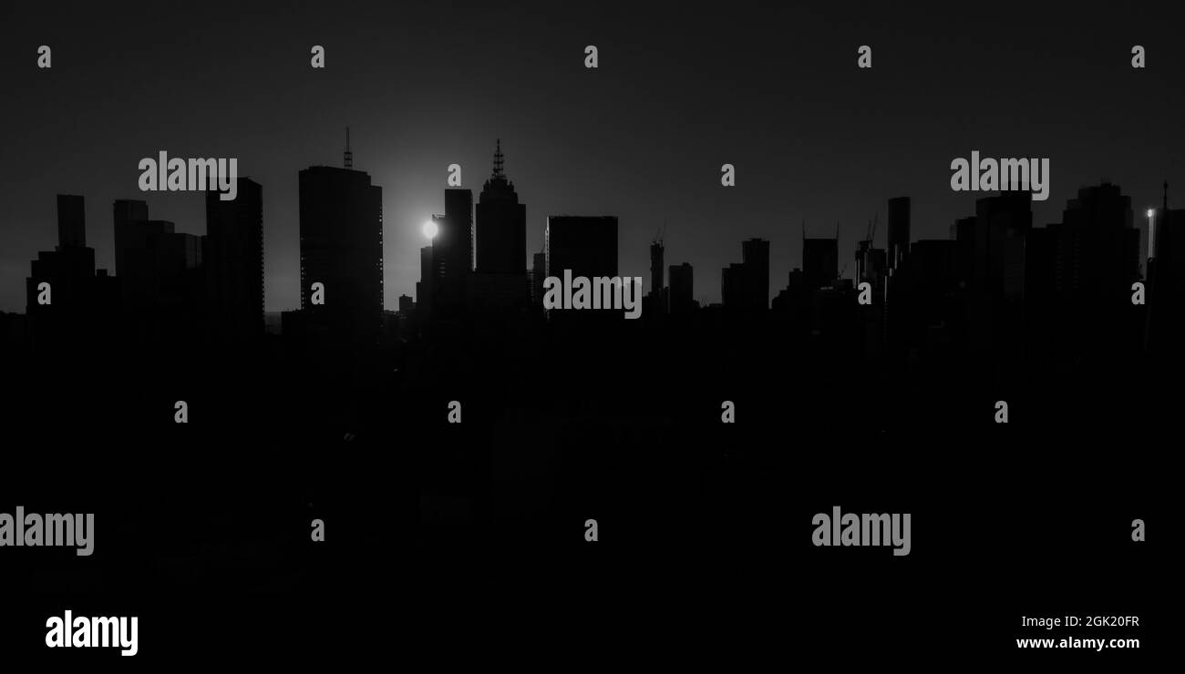 Melbourne city skyline silhouetted by a dramatic sunset in black and white Stock Photo