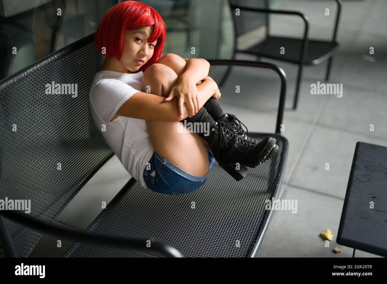 Cosplay Actress in Fetal Position on Bench | Red Blood Cell Cosplay Stock Photo
