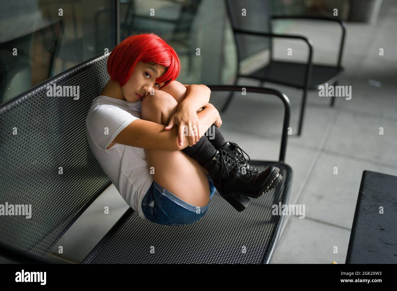 Cosplay Actress in Fetal Position on Bench | Red Blood Cell Cosplay Stock Photo