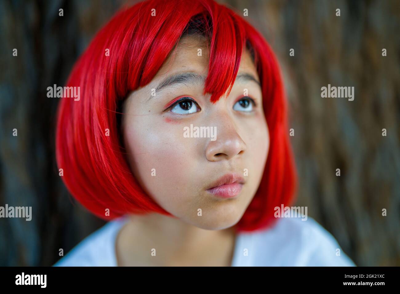 Red Blood Cell Cosplay Actress Standing with Redwood Tree | Teen Asian Girl with Red Wig Stock Photo
