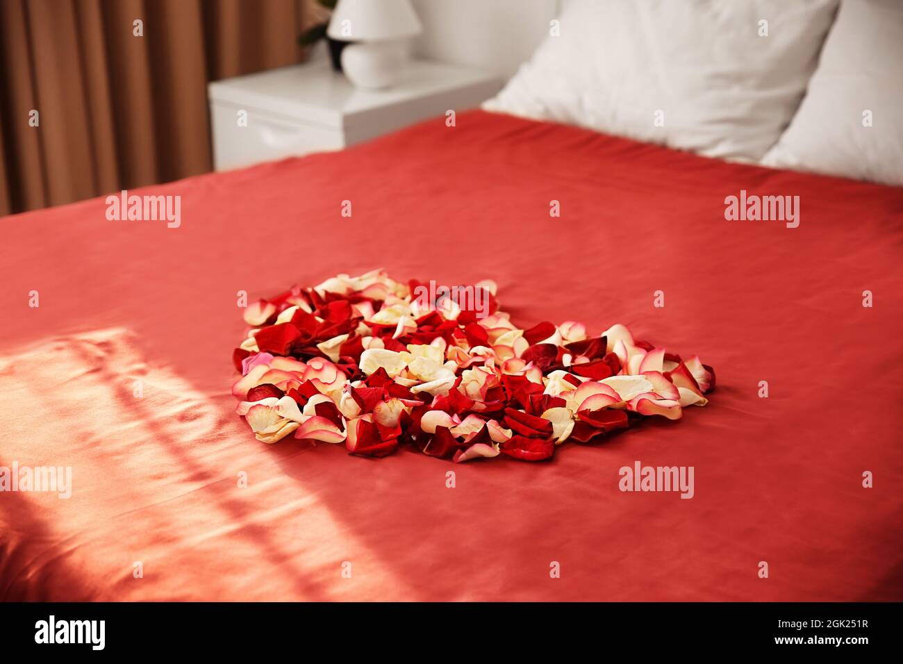 Heart made of rose petals on bed in hotel room Stock Photo Alamy