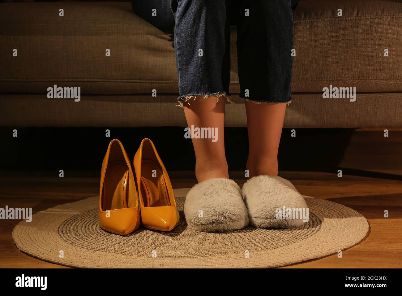 Woman wearing soft slippers after work day, closeup Stock Photo