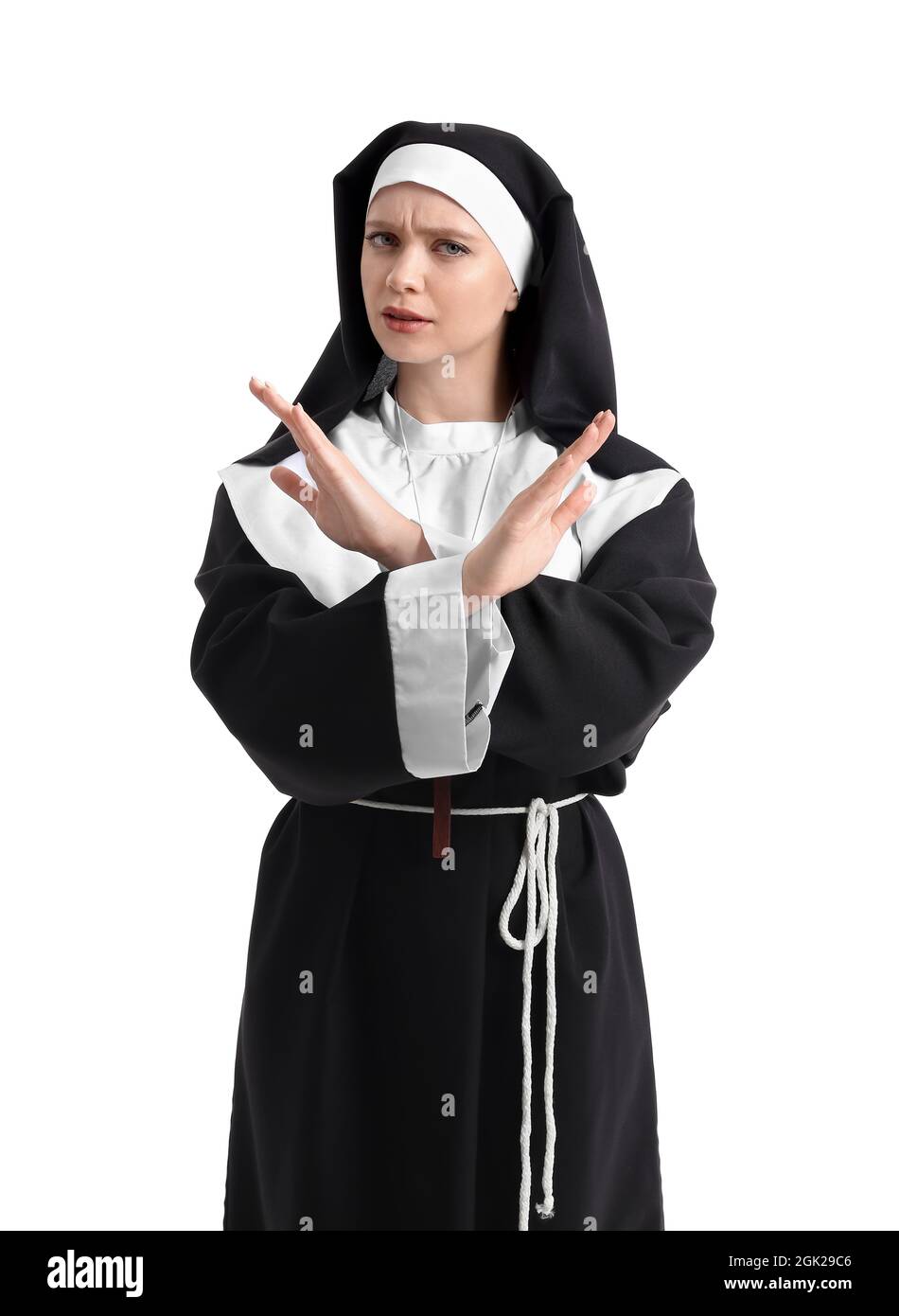 Young nun showing STOP gesture on white background Stock Photo - Alamy