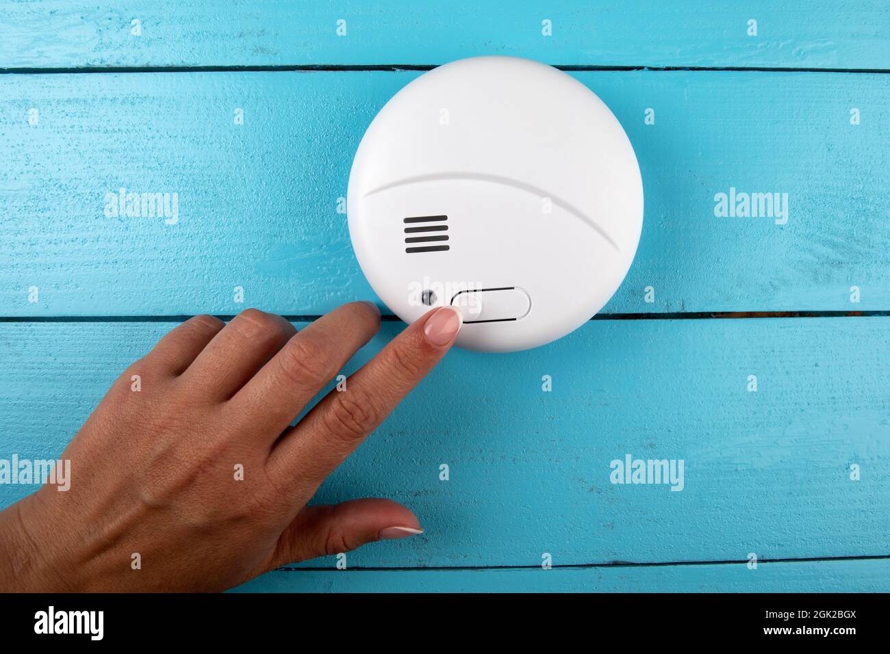 Smoke detector. Woman's finger presses the test button. Smoke, fire alarm Stock Photo Alamy