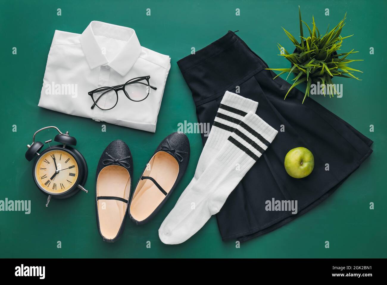 Stylish school uniform, shoes, eyeglasses and alarm clock on color background Stock Photo