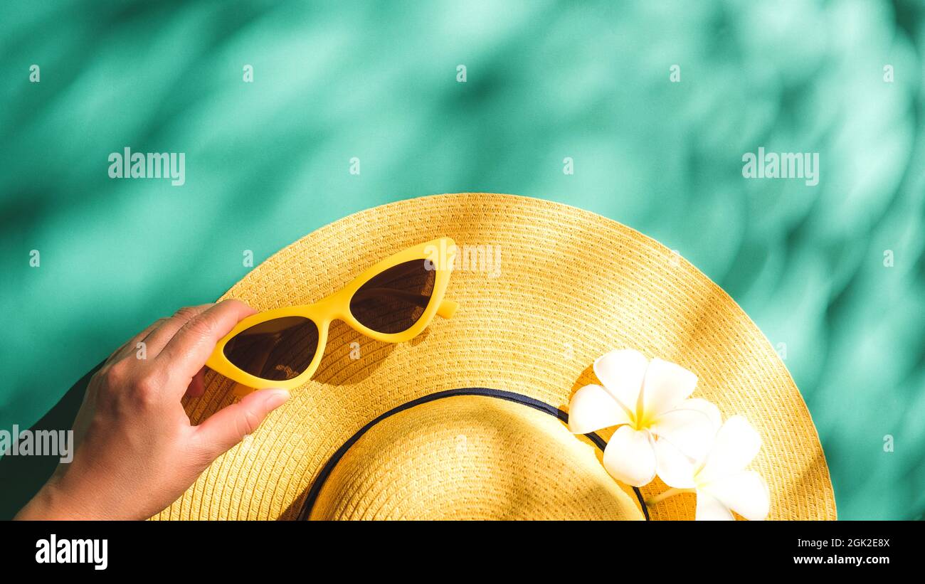 Tropical summer beach sea accessories objects,sunglasses and straw hat over green turquoise background with sunlight,minimal style, Stock Photo