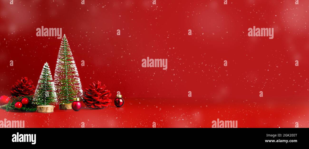 Merry Christmas and happy new year snow falling  red background with xmas tree and pine cone on.Banner mockup space for display of product or design o Stock Photo