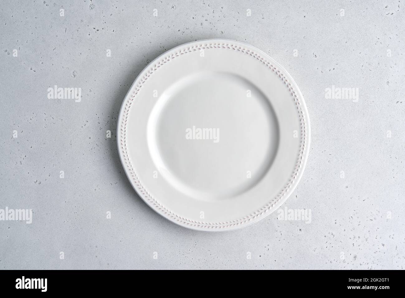 Empty white ceramic plate on light background. Copy space, top view, horizontal, closeup Stock Photo