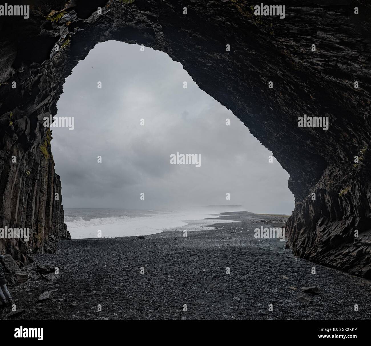 Panoramic view  of Reynisfjara beach cave in Iceland with big basalt pillars and rocky beach. Cold windi place at the beach with big waves. Stock Photo