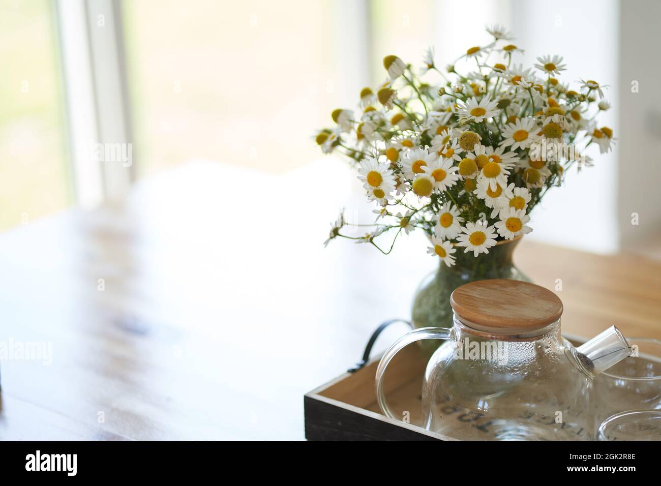 Vases with Beautiful Flowers on Table in Kitchen Interior. Stock