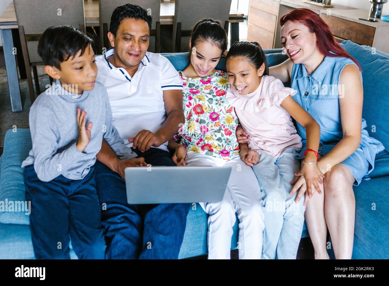 Mexican family and teenage daughter with cerebral palsy making video call on computer at home in Latin America Stock Photo