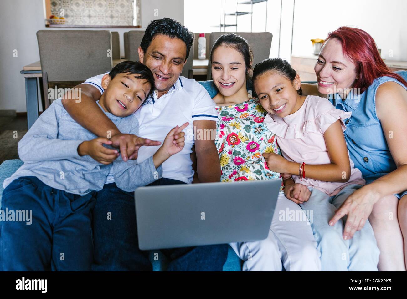 Mexican family and teenage daughter with cerebral palsy making video call on computer at home in Latin America in disability concept Stock Photo