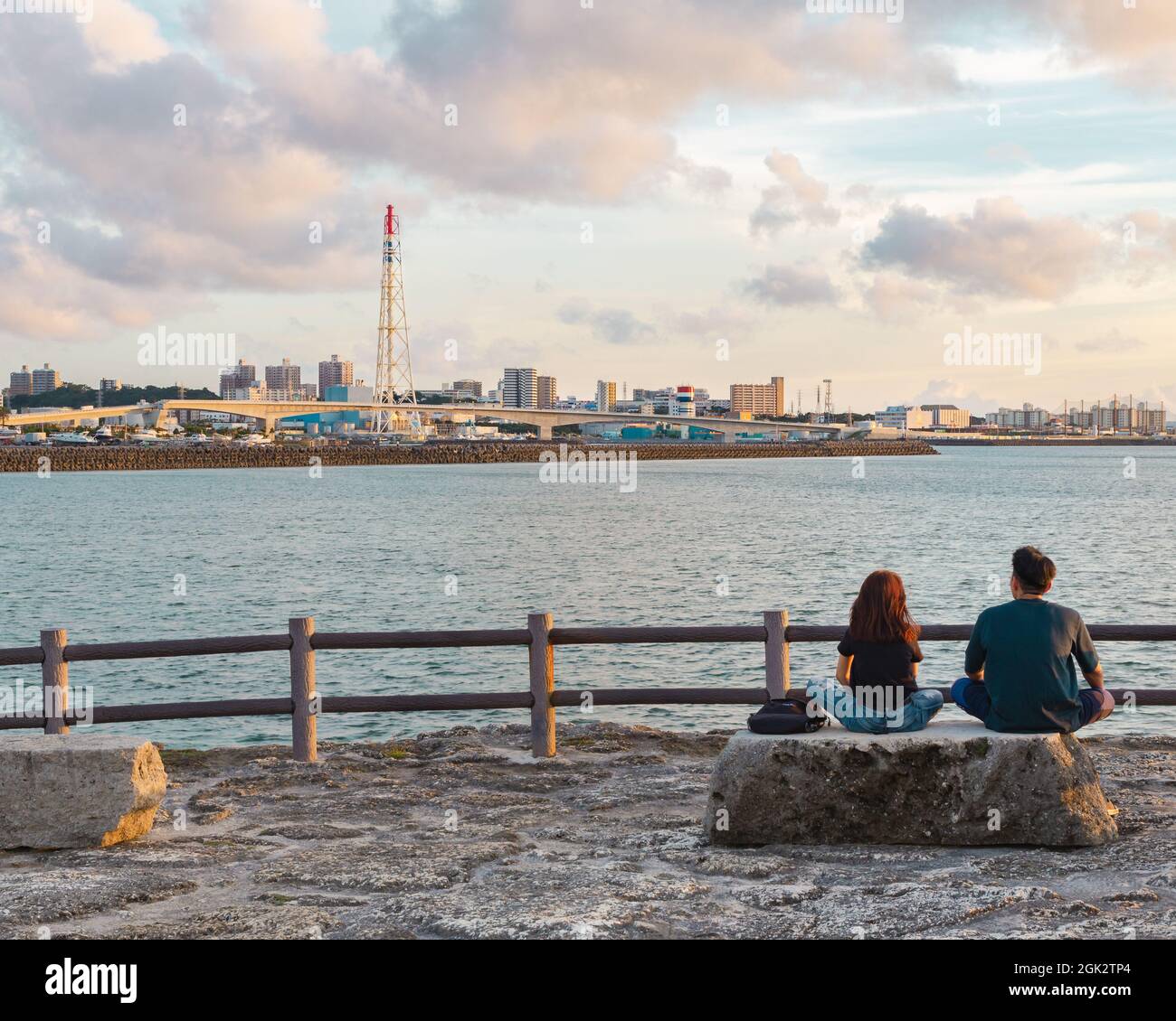Young couple in love peacefully watching a sunset in Okinawa, Japan Stock Photo