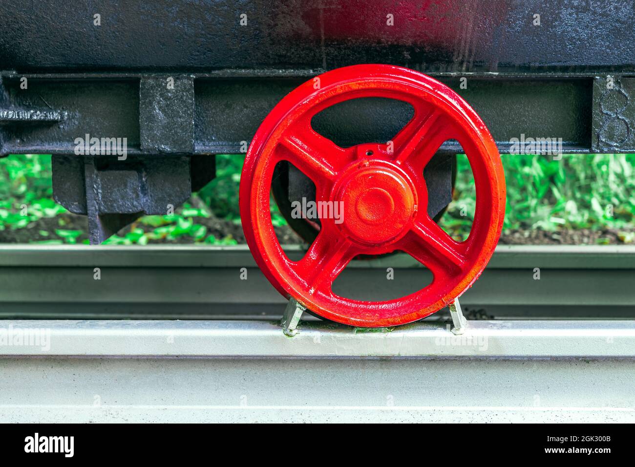 the undercarriage of a traditional mine cart. a restored, old mine car on a fragment of a railway track. the red steel wheels and the black plate of t Stock Photo