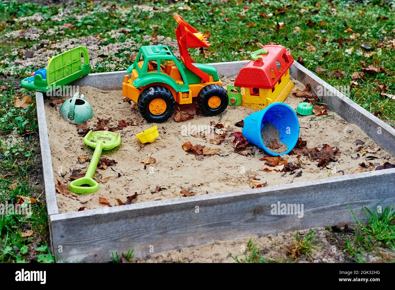 Forgotten toys in the sandbox outside. Children playground outdoors Stock Photo