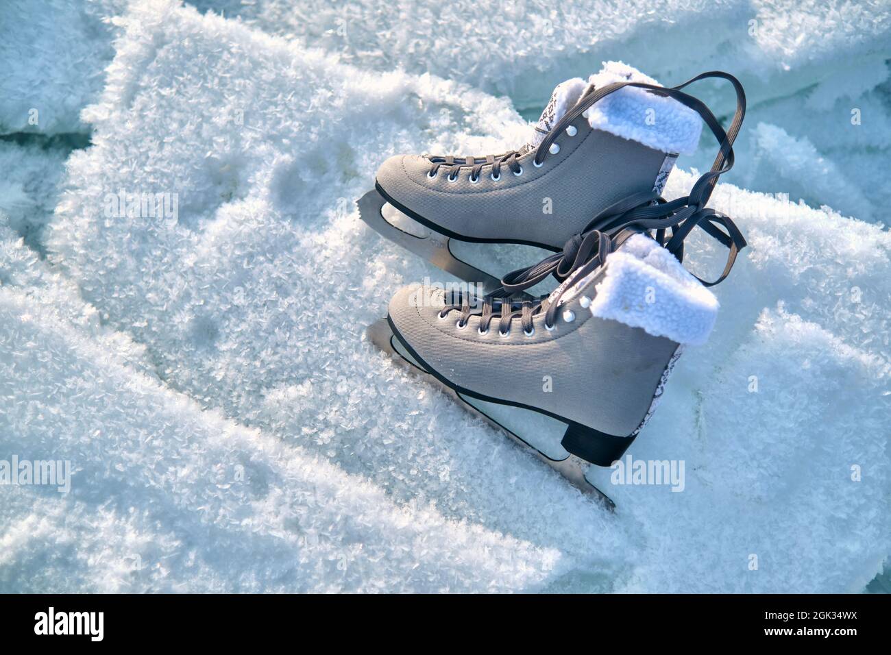 A pair of female figure skates lie on the ice Stock Photo