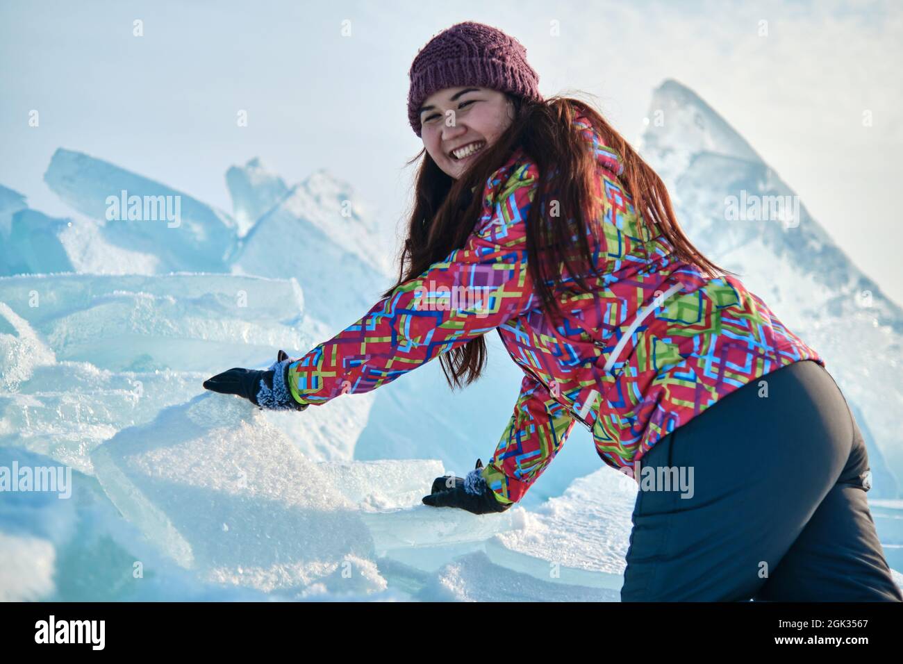 A woman in a ski suit climbs on blocks of ice, fun, fun, rest, winter Stock Photo