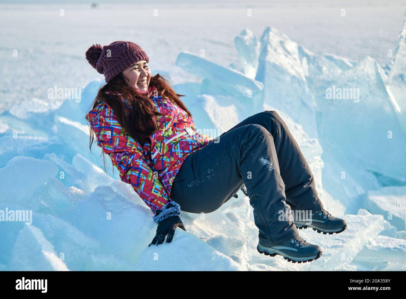 A woman in a ski suit climbs on blocks of ice, fun, fun, rest, winter Stock Photo