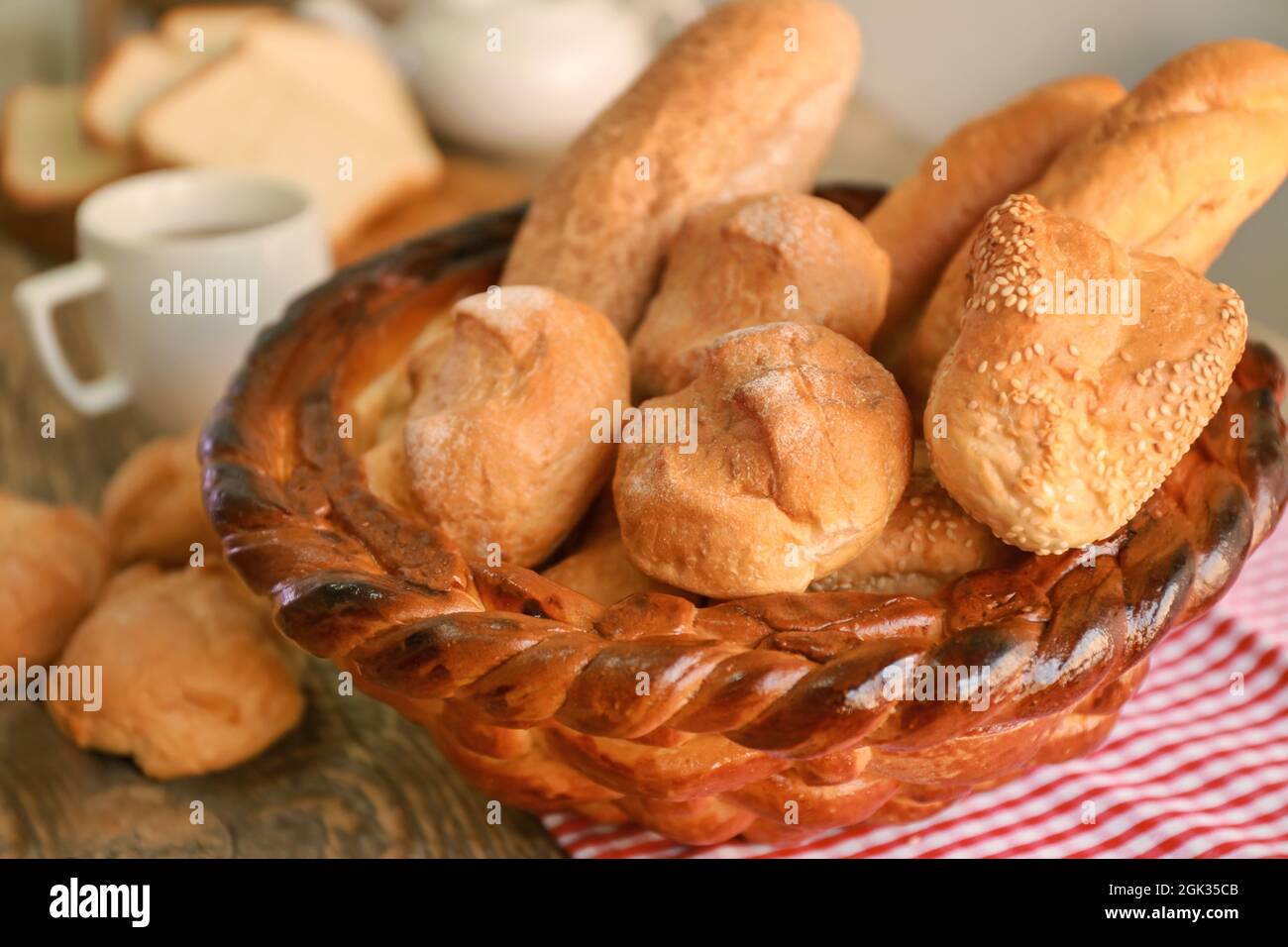 Braided bread basket with delicious loaves on table Stock Photo Alamy