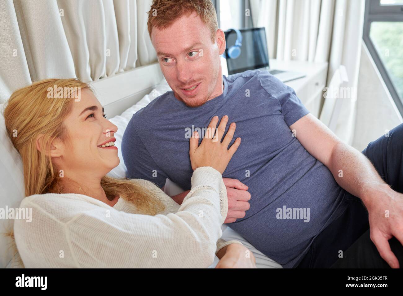 Young woman touching chest of her boyfriend when laughing at his funny story Stock Photo