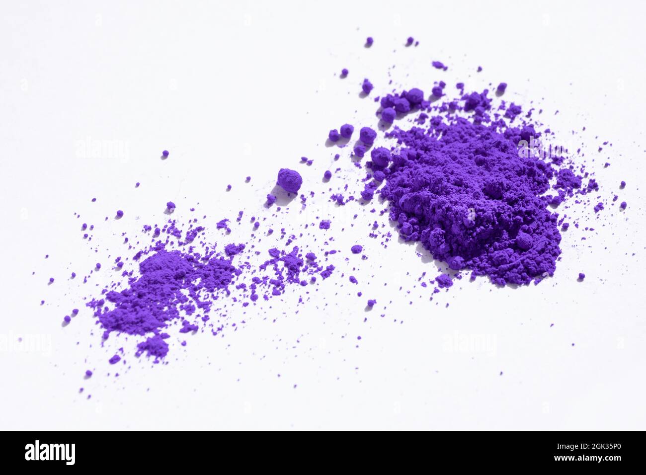 Close up of a portion of purple pigment isolated on white in side view. The pigment will be mixed with linseed oil to make oil paint Stock Photo