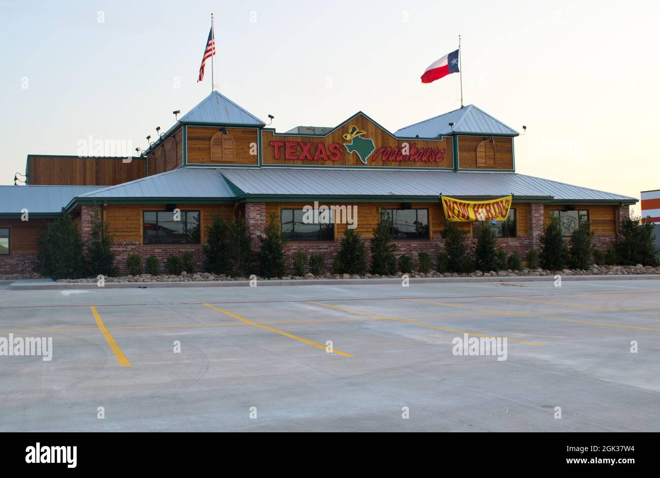 Humble, Texas USA 09-06-2019: Texas Roadhouse steakhouse in Humble, TX with a hiring sign out front. Parking lot in the foreground with flag on roof. Stock Photo