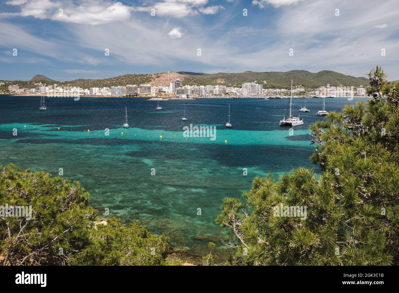 Bay of Ibiza coastline with turquoise water and yachts on sunny summer day. View to the Port de Sant Antoni de Portmany Stock Photo