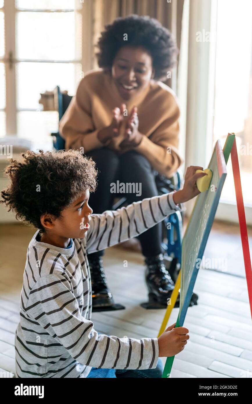 Happy woman with disability learning together with a child. People education fun concept Stock Photo