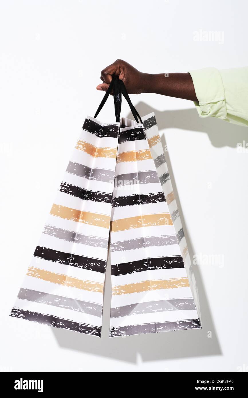 Close-up of woman holding shopping bags with purchases isolated on white background Stock Photo