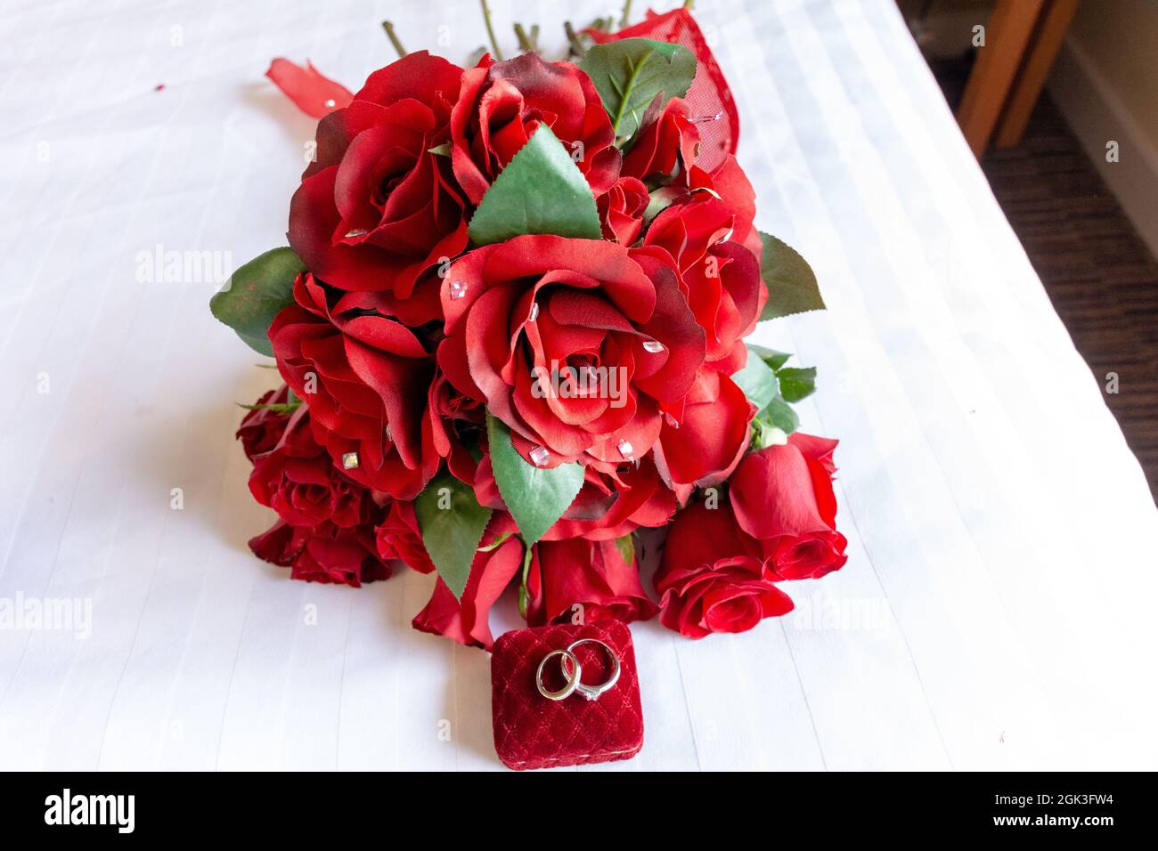 bouquet of red roses with wedding rings Stock Photo