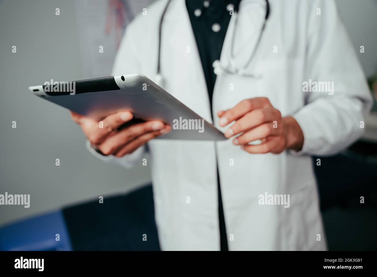 Mixed race male nurse standing in office holding digital tablet Stock Photo
