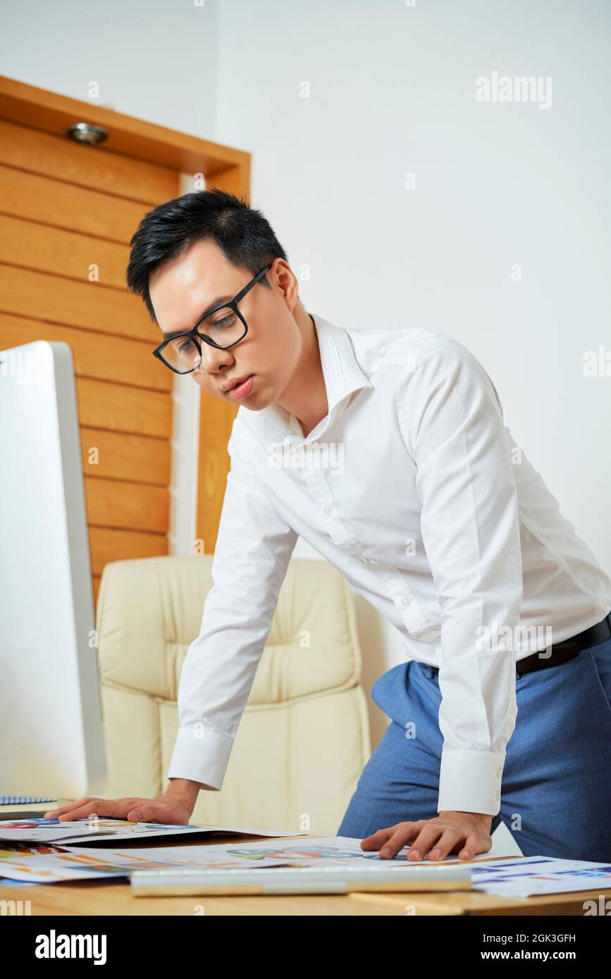 UI designer leaning on his office desk when working on perfect mobile application layout Stock Photo