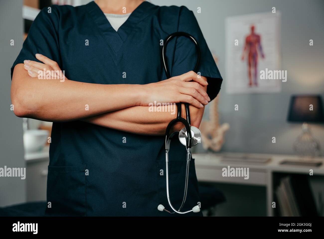 Caucasian female doctor standing in clinic with arms crossed  Stock Photo