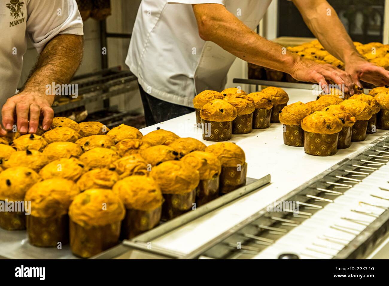 Pasticceria Marnin in Locarno, Switzerland. The little ones ahead! Mini panettone of 100 g are the first to leave the oven and are skewered on a rack to cool overhead. Panettone Prduction in the Pasticceria Marnin in Locarno, Switzerland. Circolo di Locarno, Switzerland Stock Photo