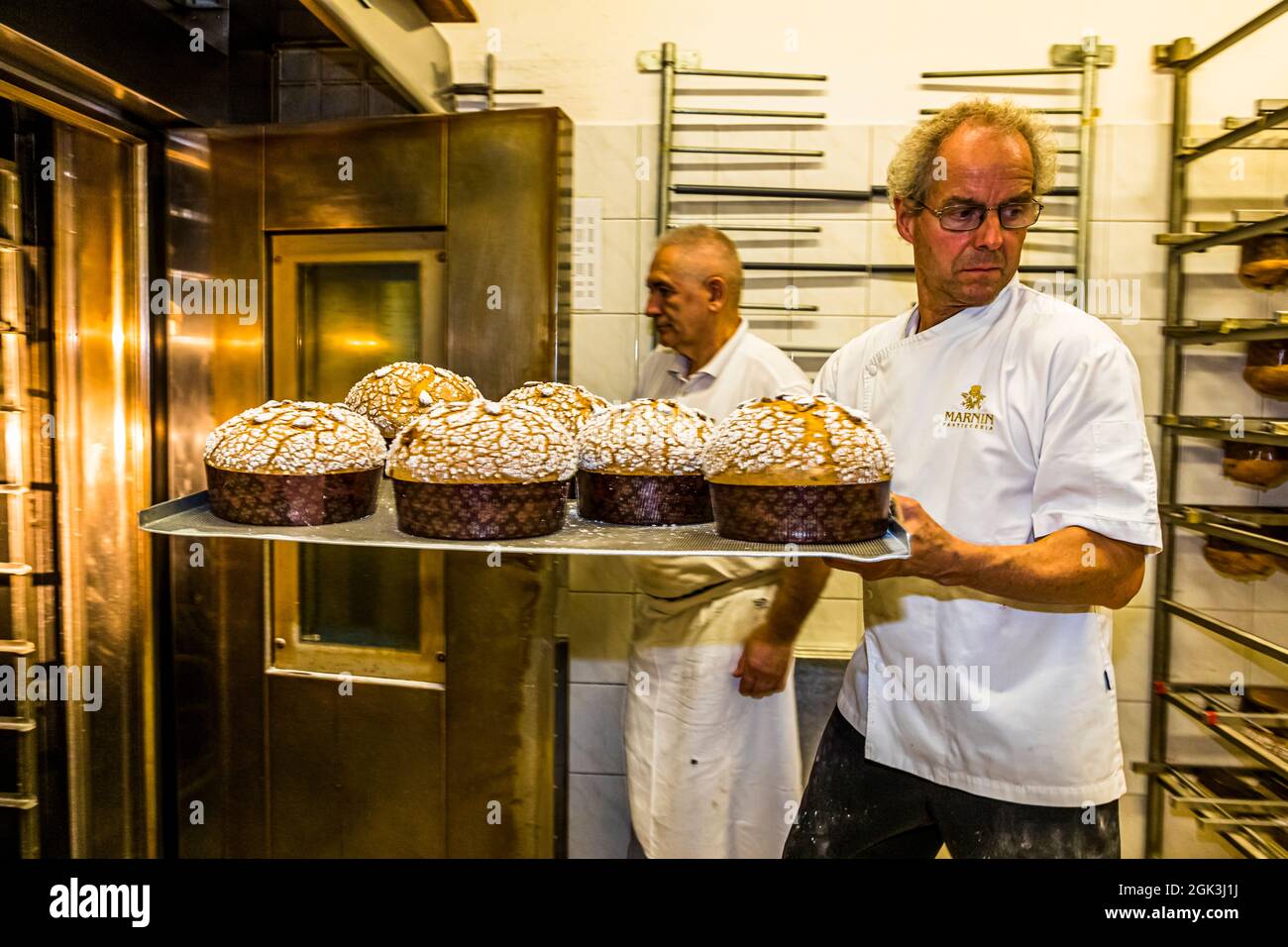 Panettone Prduction in the Pasticceria Marnin in Locarno, Switzerland. The Panettone Maron come out of the oven like snow-covered domes. The snow sugar remains crunchy for a long time and forms a great contrast to the airy and mouth-filling inside Stock Photo