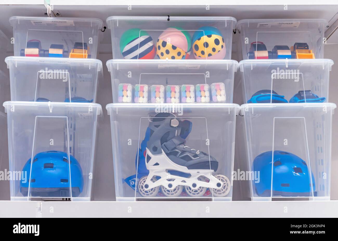 Plastic boxes with children's toys, rollers and a helmet Stock Photo