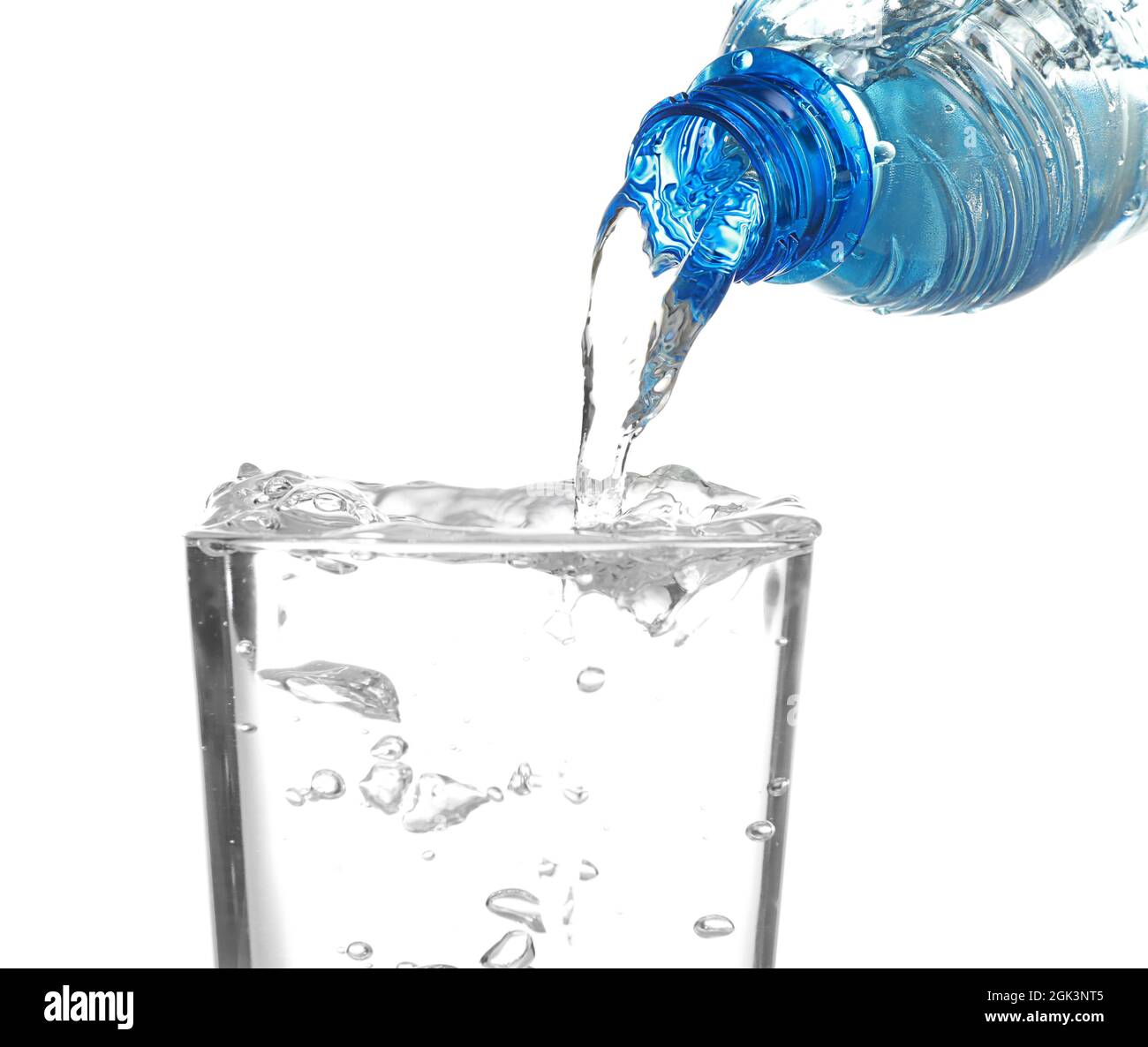 Water pouring from bottle into glass on white background Stock Photo