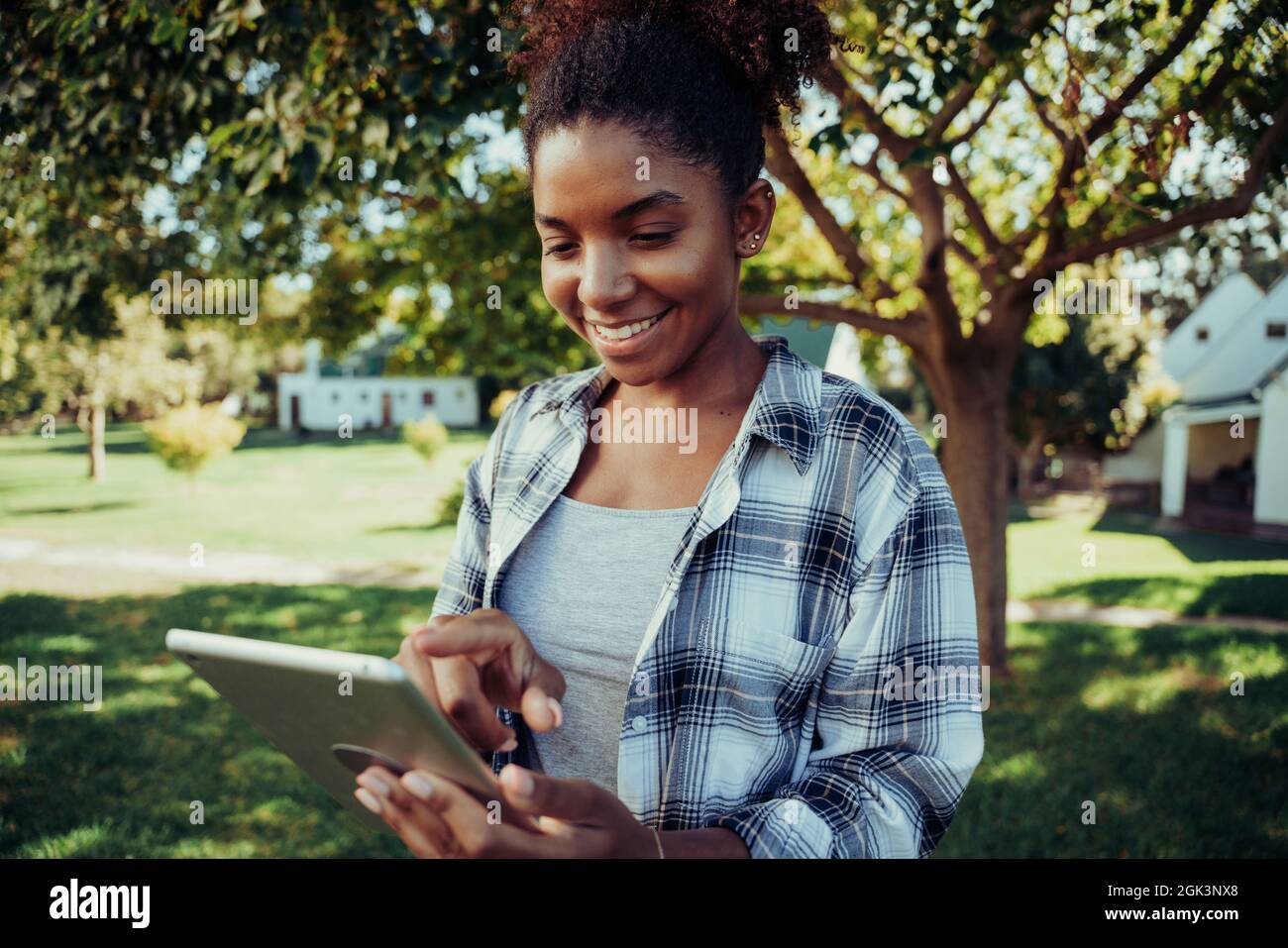 Mixed race female typing on digital tablet studying for test in the outdoors  Stock Photo